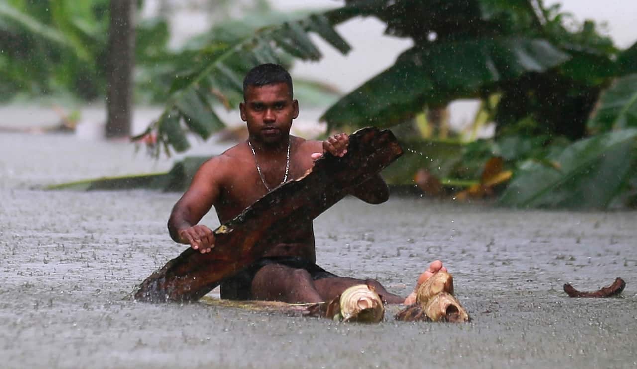 A Sri Lankan man rows a makeshift raft on a flooded road in Wehangalla village in Kalutara district, Sri Lanka, Saturday, May 27, 2017. (AAP)