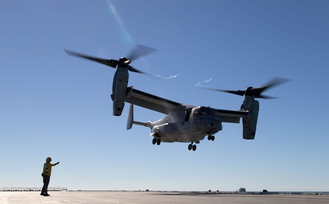 A HMAS Canberra crewmember directs an American V22 Osprey helicopter on the ship’s flight deck during joint Australian-US  operation Exercise Talisman Saber.