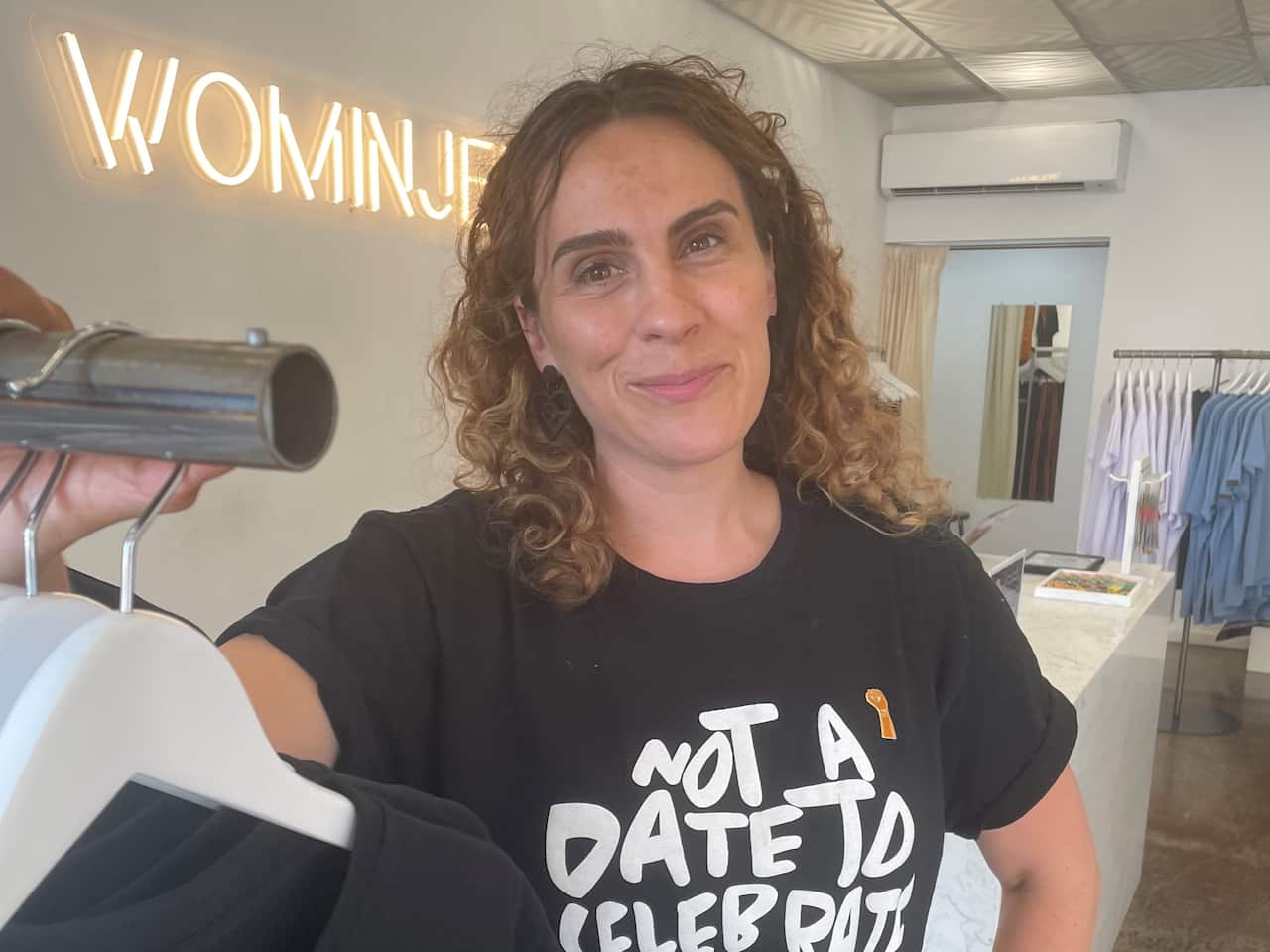 Laura Thompson wears a black t-shirt with 'not a date to celebrate' written in white across the front.