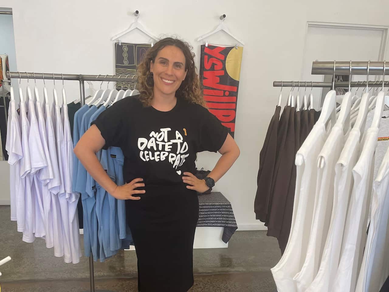 A woman wears a black t-shirt with 'not a date to celebrate' written across it.