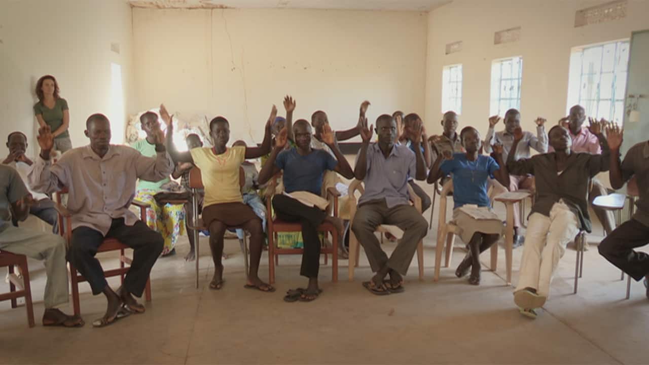 Kik watches as Raymond Okkelo's class learns how to speak using sign language.