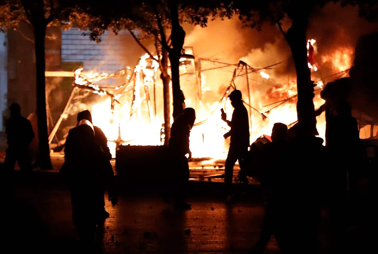 Tents, erected by protesters, are set alight as the clashes go on into the night. 