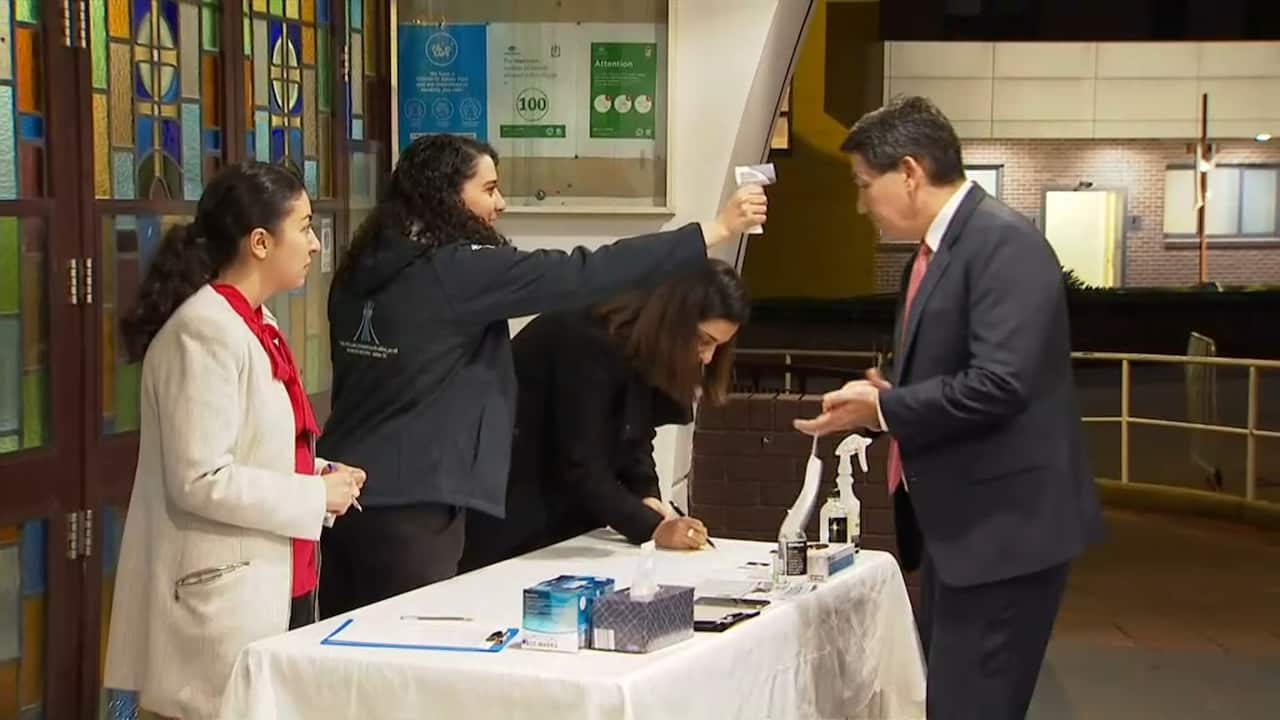 Those attending the service at Our Lady of Lebanon Maronite Church in Western Sydney have their temperature checked on entry