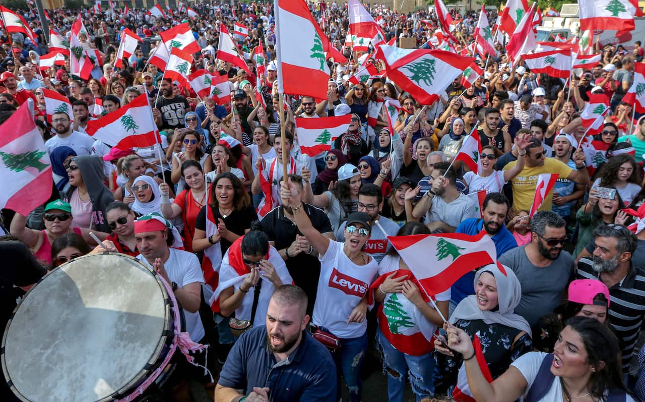 Protesters wave flags during a protest in front the Government palace in downtown Beirut, Lebanon.