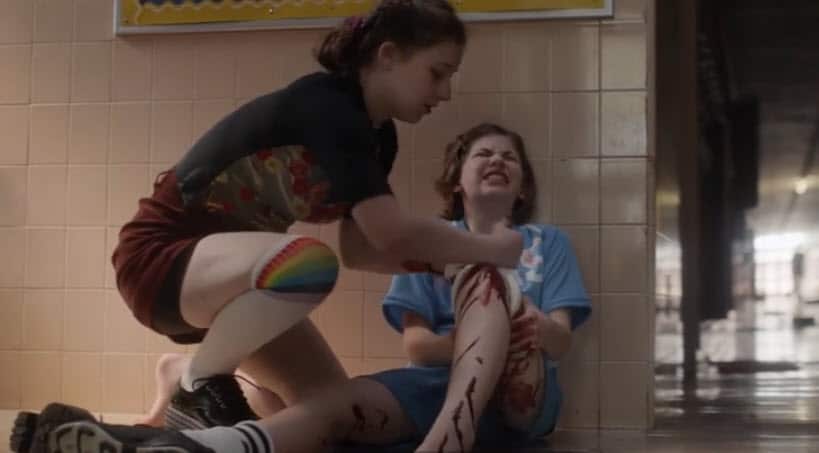 A student uses her new gym socks to offer first aid to a friend shot in the leg.