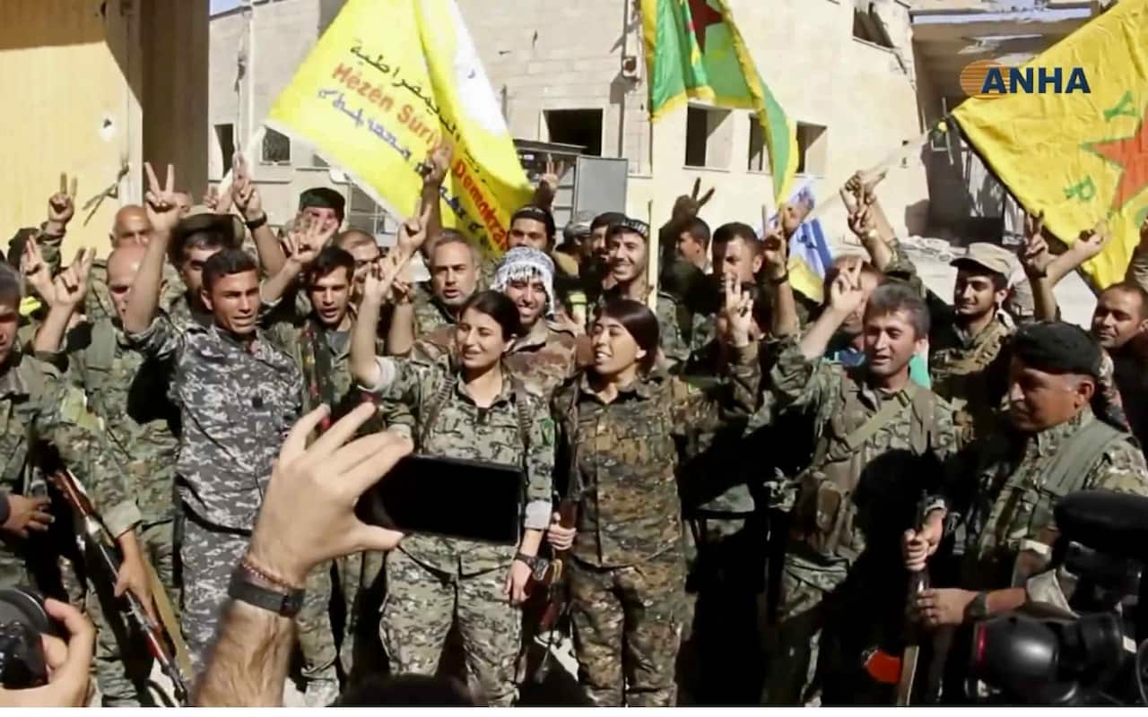 Fighters from the U.S.-backed Syrian Democratic Forces (SDF) celebrating their victory in Raqqa, Syria (AAP)