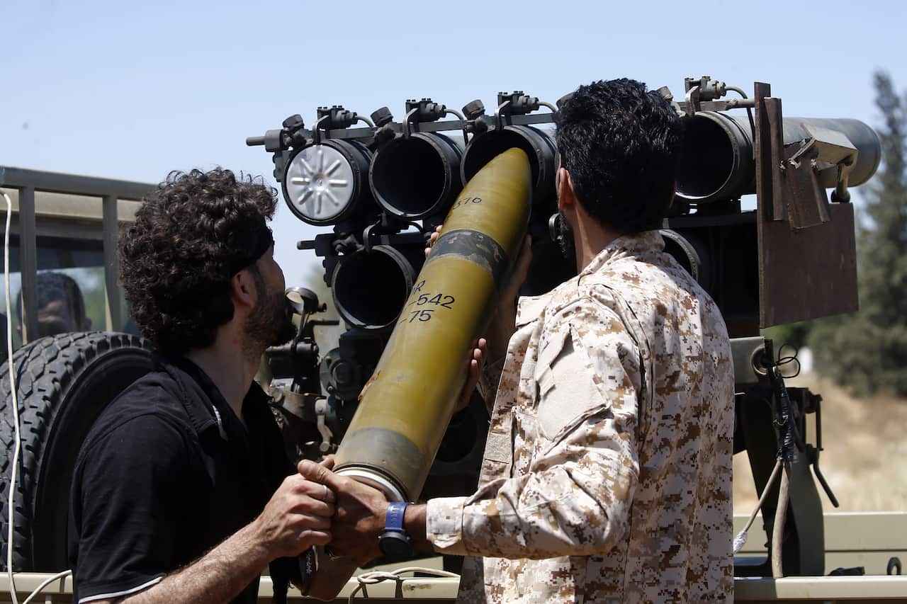 Fighters loyal to the internationally-recognised Government of National Accord (GNA) load a cannon during clashes with forces loyal to strongman Khalifa Haftar.