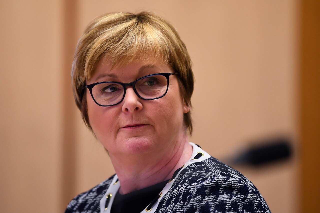 A woman wearing glasses looking to the side. 