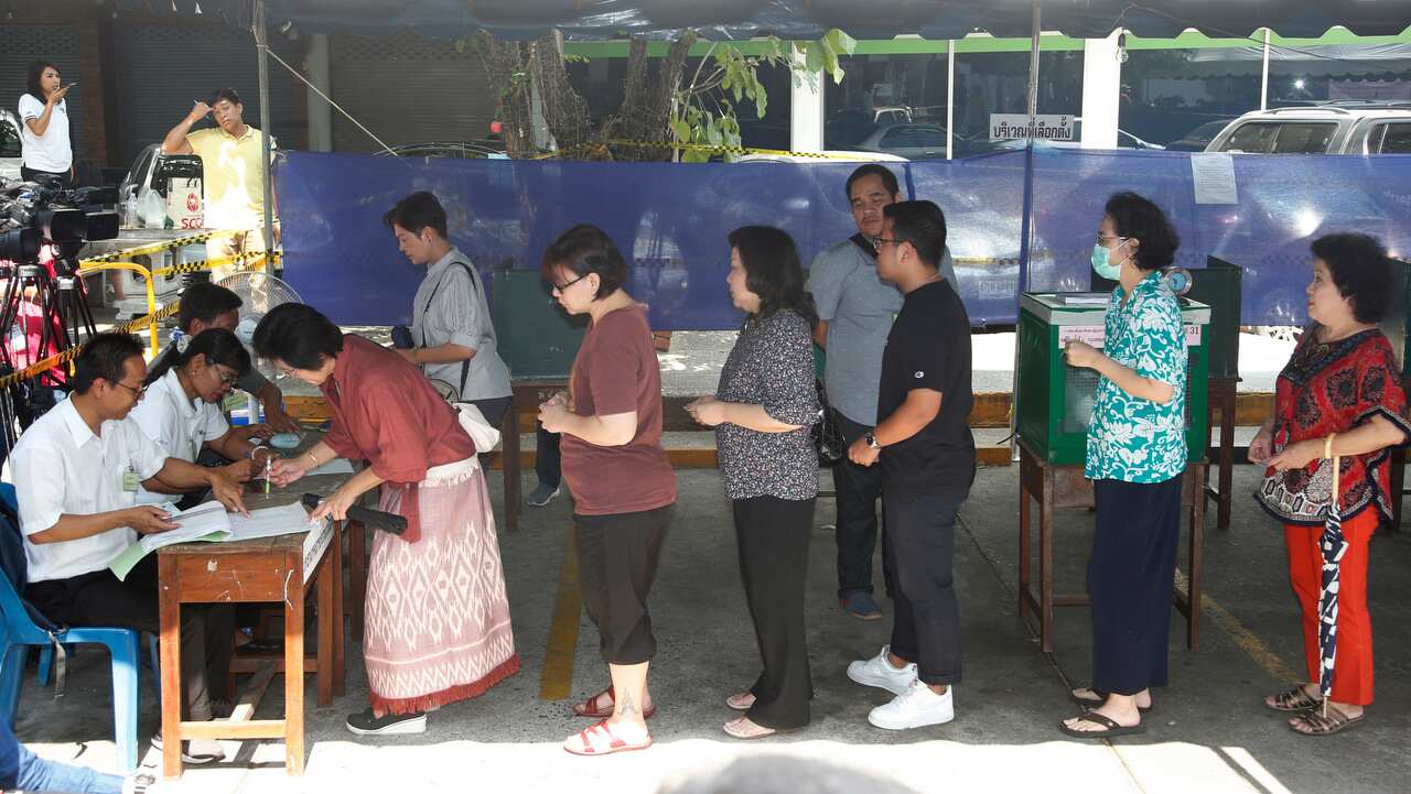 People line up for voting in general election at a polling station in Bangkok.