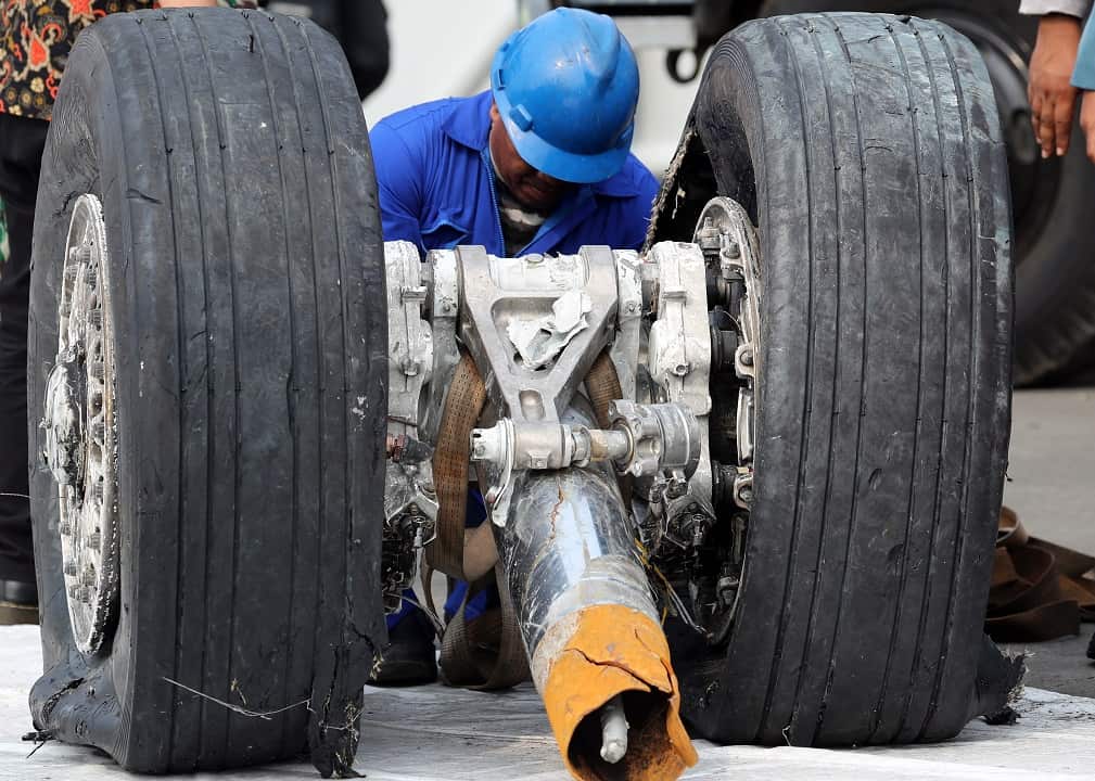 An Indonesian official inspects a recovered wheels of the crashed Lion Air flight JT610.