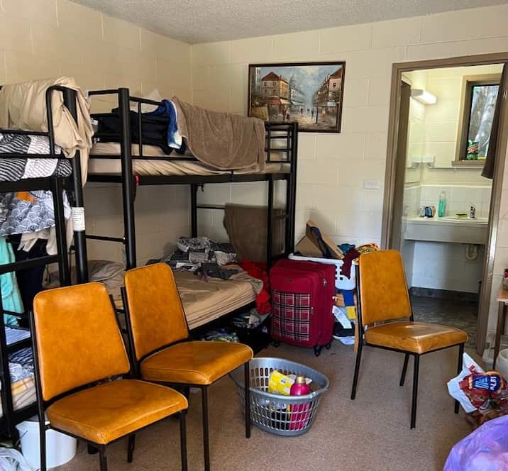 Four men each share one room with double bunk beds in Warburton, Victoria. No pantries, drawers or fans are provided.