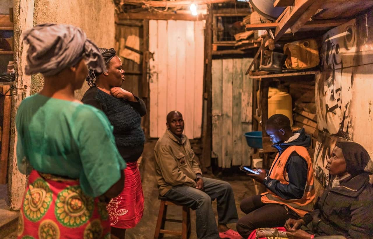 Worker of the Census enumeration Dennis Okoth, asks questions to Samson Nteng'a Omare and his family in Nairobi
