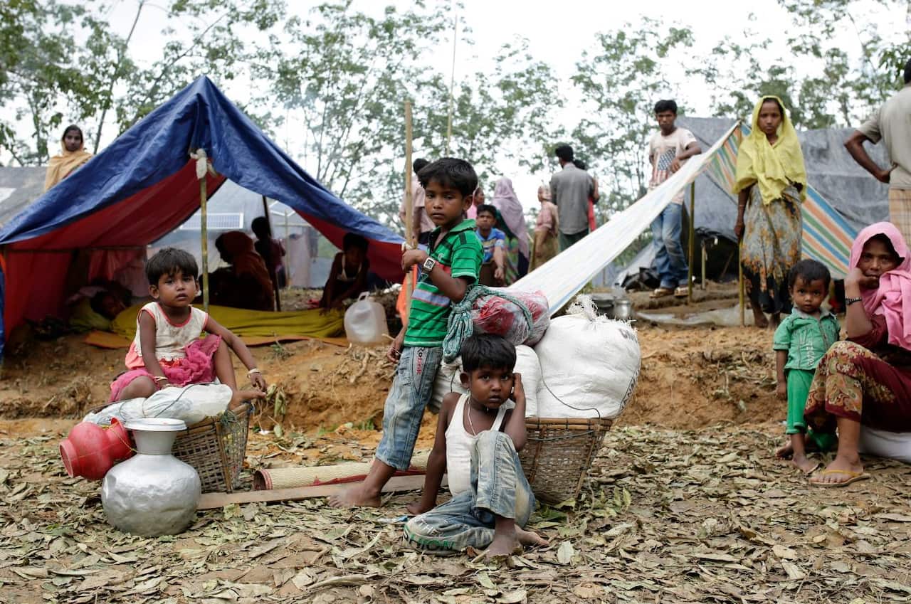 Rohingya family sit in front of their makeshift shelters in a camp in Ukhiya, Cox's Bazar, Bangladesh, 11 September 2017 (AAP)