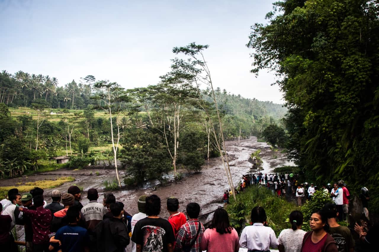 People gather on the banks of the Yeh Sah River in Karangasem Regency of Bali, Indonesia on November 27, 2017 to observe the lahar from Mount Agung (AAP)