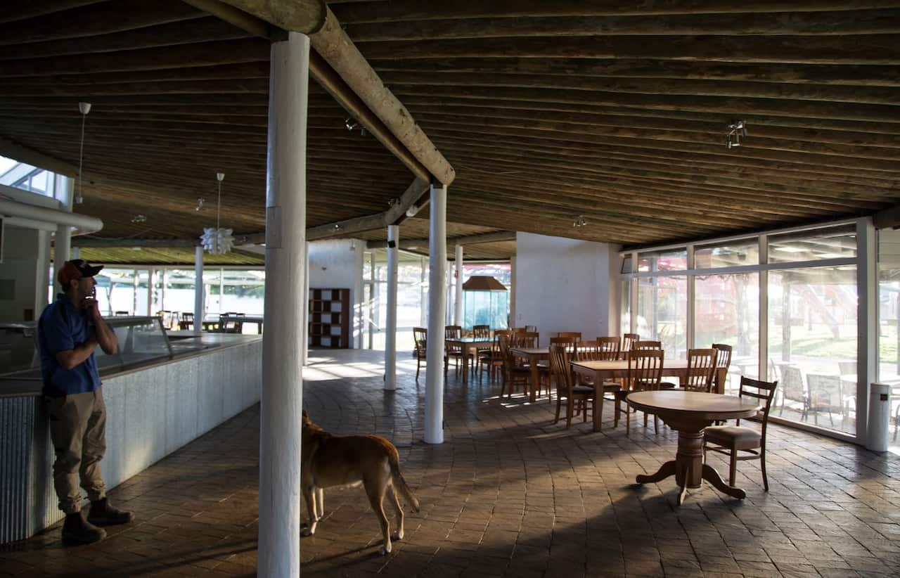 Casey Sharpe and his dog, Max, in the closed restaurant behind The Big Lobster, in Kingston South East, Australia, Aug. 1, 2018.