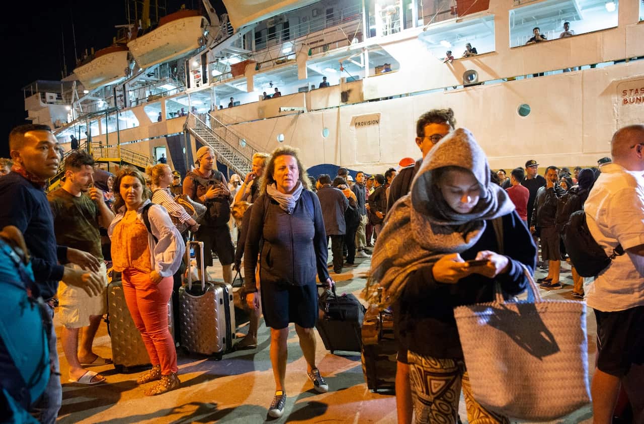 Foreign and domestic tourists which are evacuated from Gili island in Lombok following the earthquake, arrive at Benoa port in Bali, Indonesia