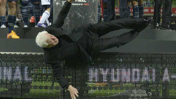 Football Federation Australian chairman Frank Lowy falls off the stage at the A-League Grand Final between Melbourne Victory and Sydney FC at AAMI Park in Melbourne, Sunday, May 17, 2015. (AAP Image/Tracey Nearmy) NO ARCHIVING