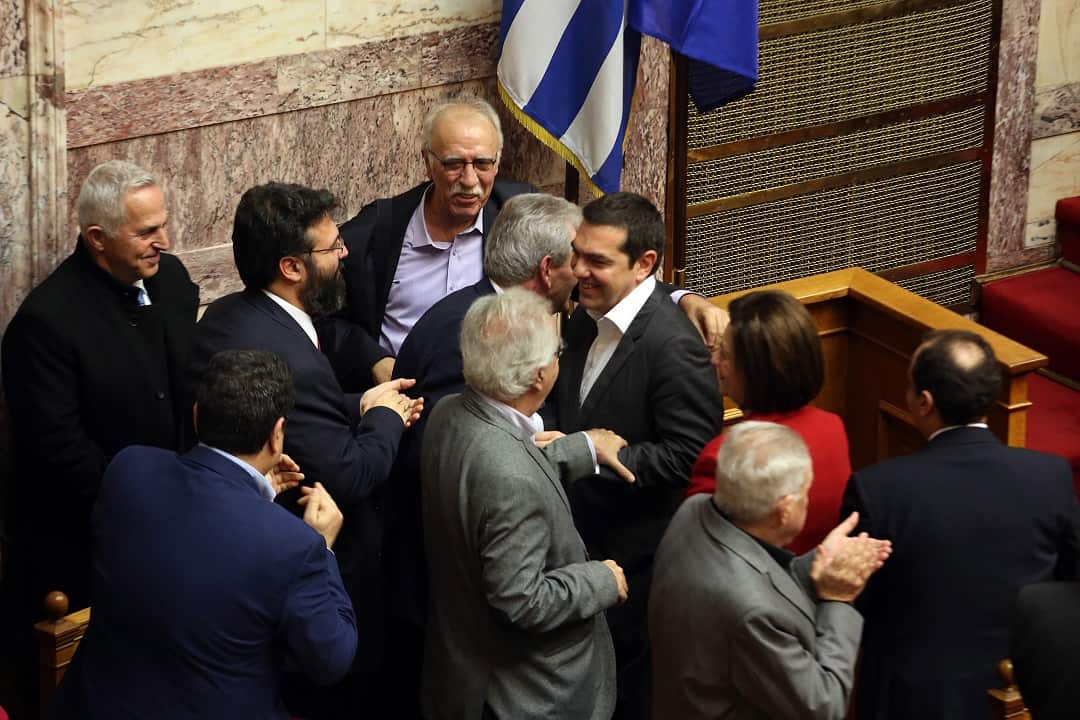 Greek Prime Minister Alexis Tsipras celebrates with other MPs after ratifies a historic agreement to settle a long-running dispute over Macedonia's name.