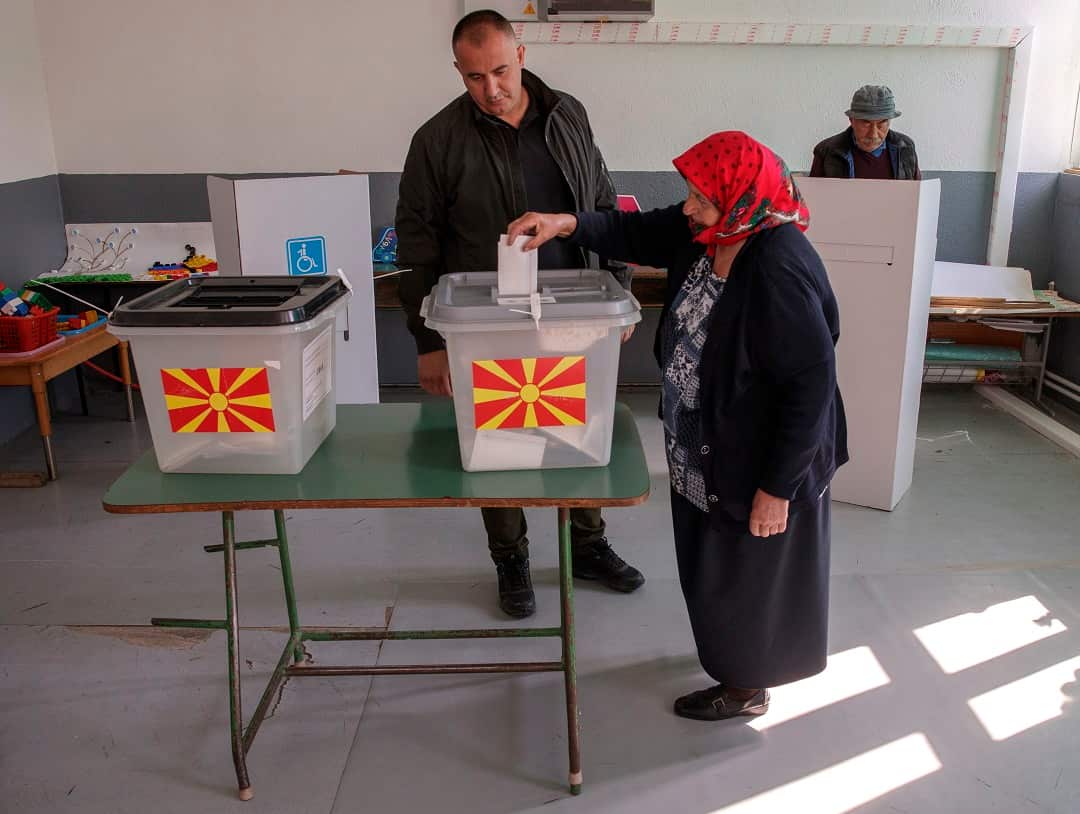 A woman casts her vote in a referendum on the country's name change at a polling station in the village of Zajas.