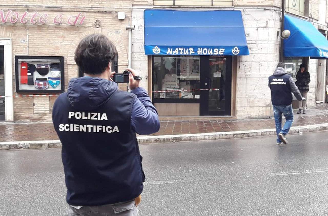 Forensic policemen take pictures to the site of a shooting which broke out in Macerata, Italy.