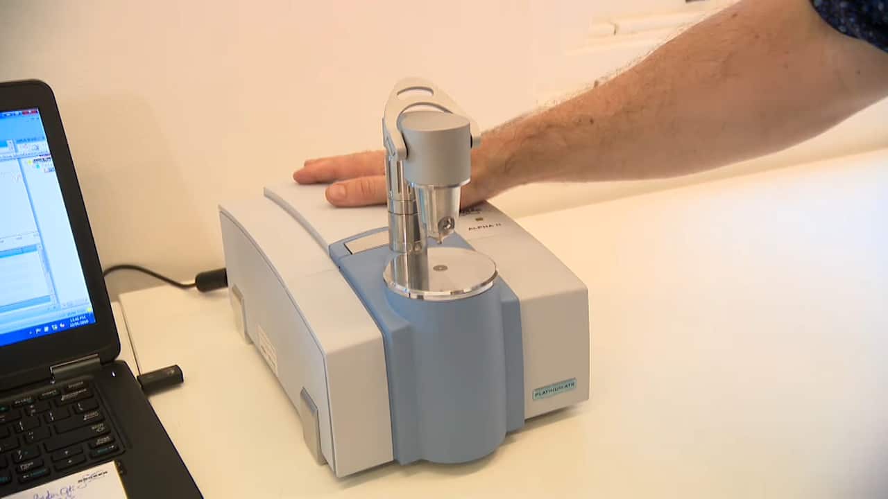 Dr David Caldicott, the clinical lead of Pill Testing Australia, demonstrates how a pill testing machine works. 