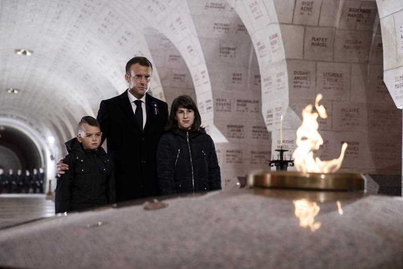 Mr Macron flanked by two young students pays his respect at the Douaumont Ossuary as part of ceremonies marking the centenary of the First World War.