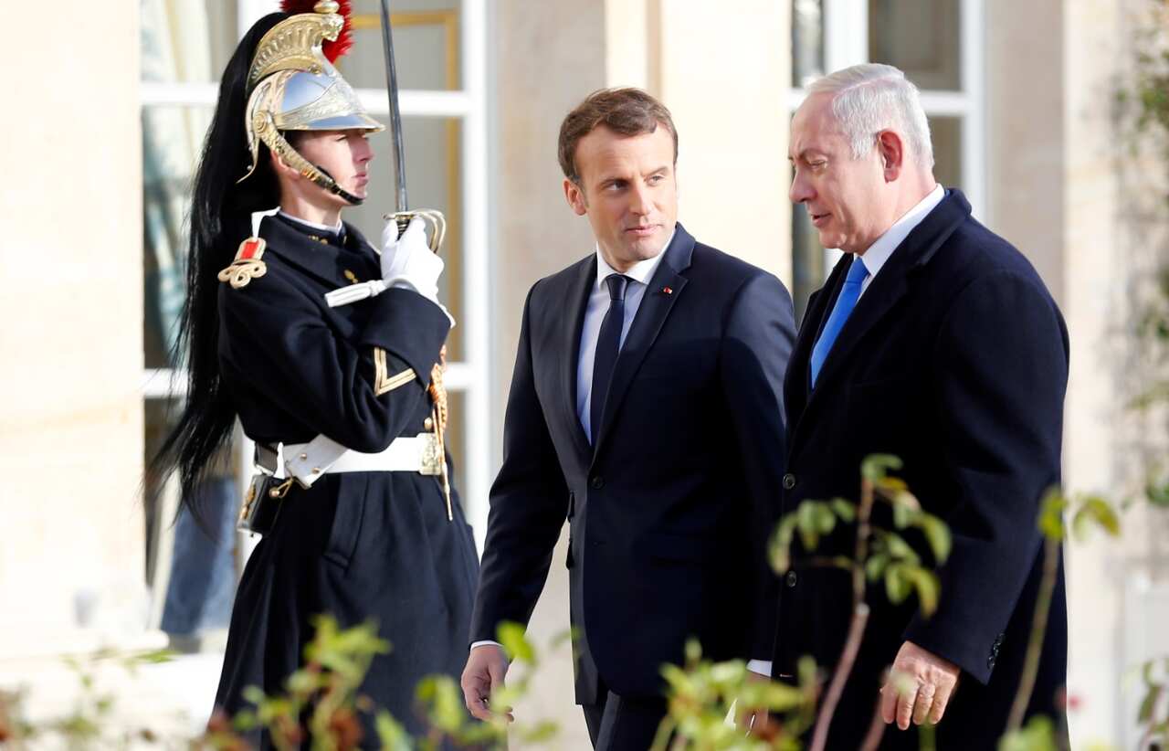 French President, Emmanuel Macron (L) welcomes Israeli Prime Minister Benjamin Netanyahu prior to their meeting at the Elysee Presidential Palace