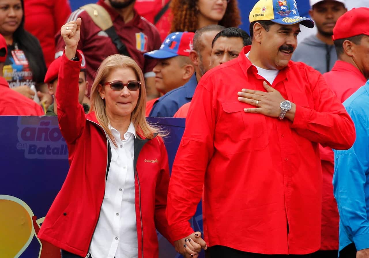 Venezuela's President Nicolas Maduro and first lady Cilia Flores acknowledge supporters at the end of a rally in Caracas, Venezuela.