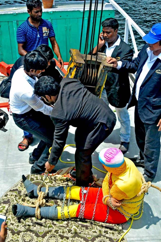 Indian stuntman Chanchal Lahiriis prepared for being lowered into the Ganges river, while tied up with steel chains and ropes, in Kolkata.