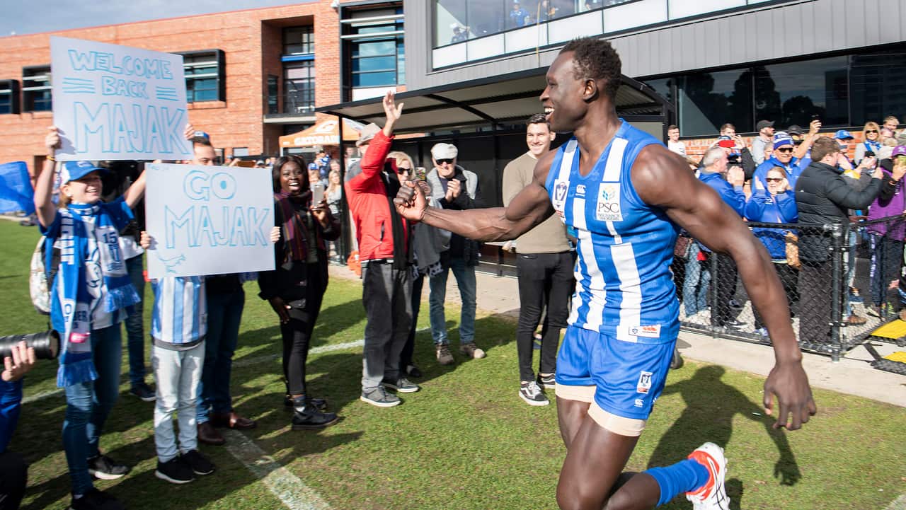 North Melbourne player Majak Daw is greeted by fans.