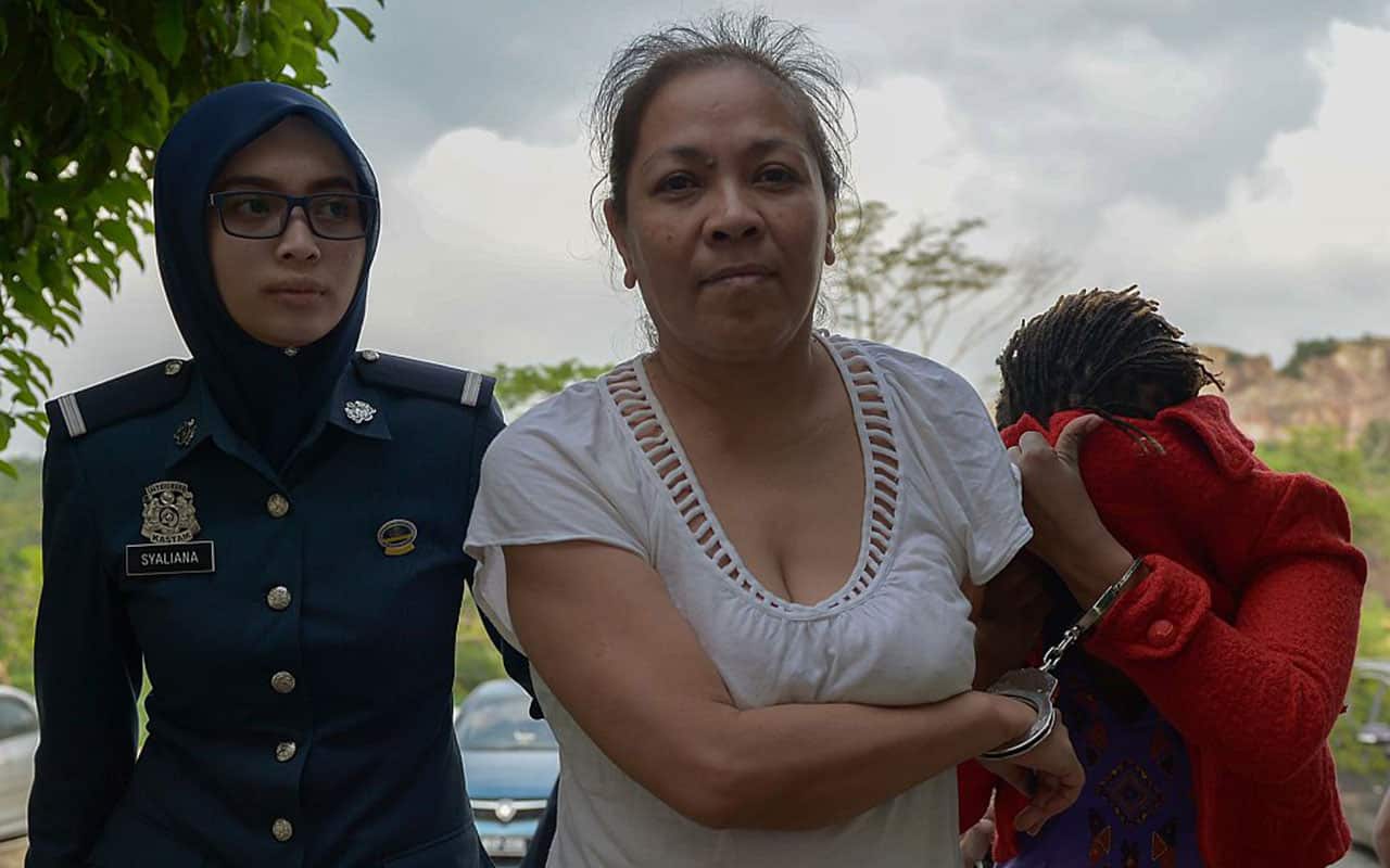 Australian national Maria Elvira Pinto Exposto is escorted by a Malaysian custom official as she arrives at the Magistrate Court in Sepang on April 30, 2015.
