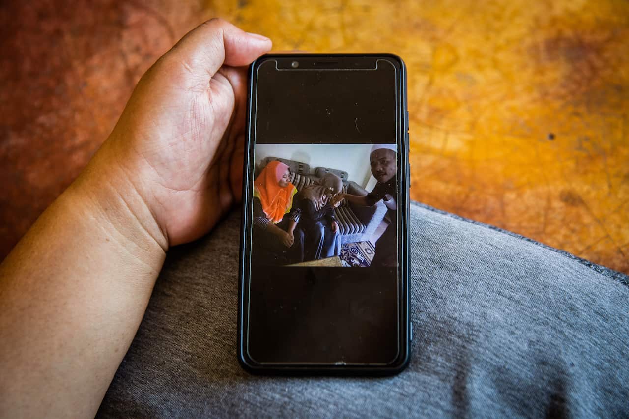 Nuraini Che Nawi, the first wife of Che Abdul Karim Che Abdul Hamid, shows a photo of her husbands marriage to Ayu, 11, his third wife, in Gua Musang, Malaysia.