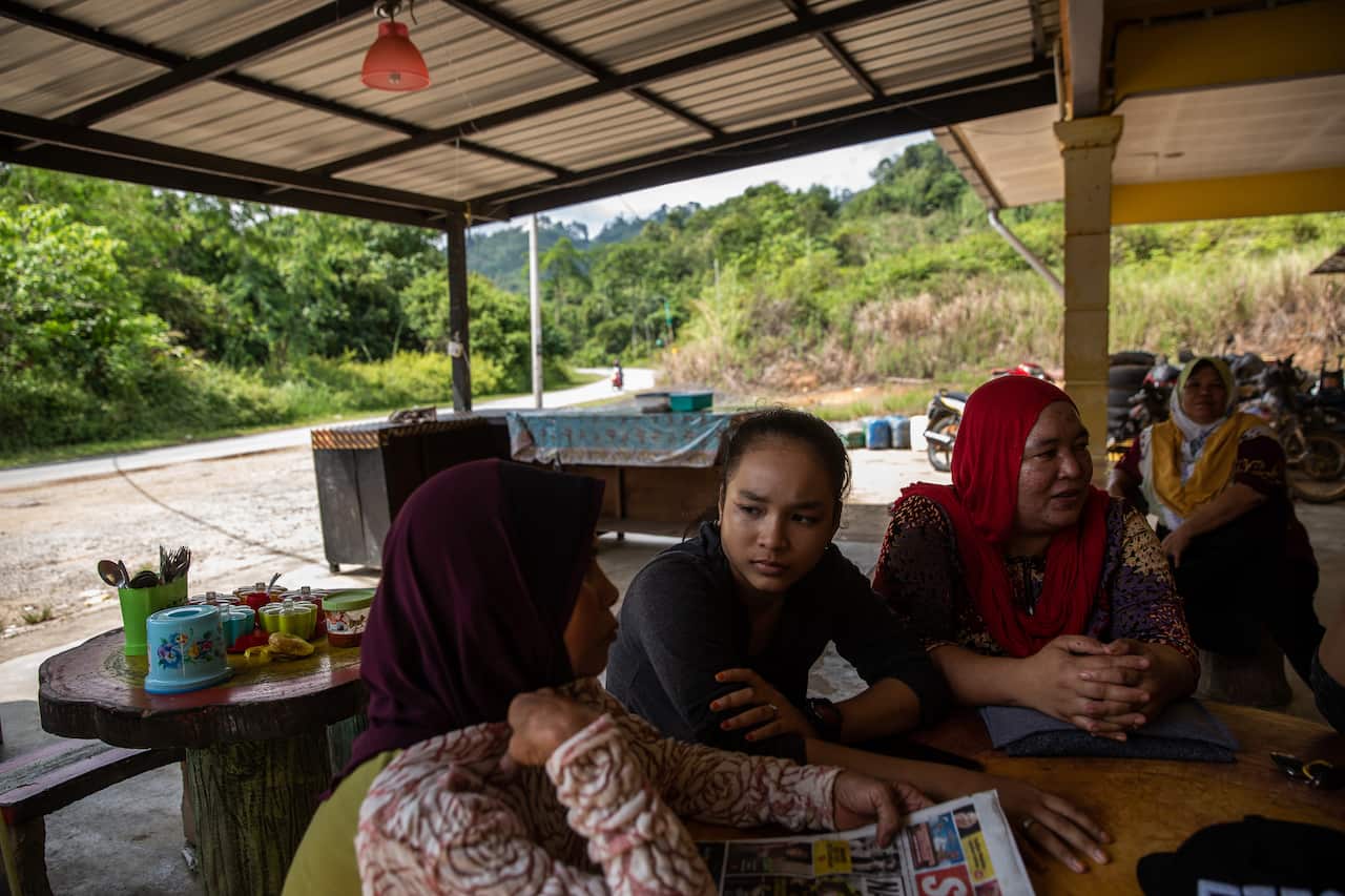 Nuraini Che Nawi, right, the first wife of Che Abdul Karim Che Abdul Hamid, and her 14-year-old daughter, Norazila, center, at the family's restaurant in Gua Musang, Malaysia.