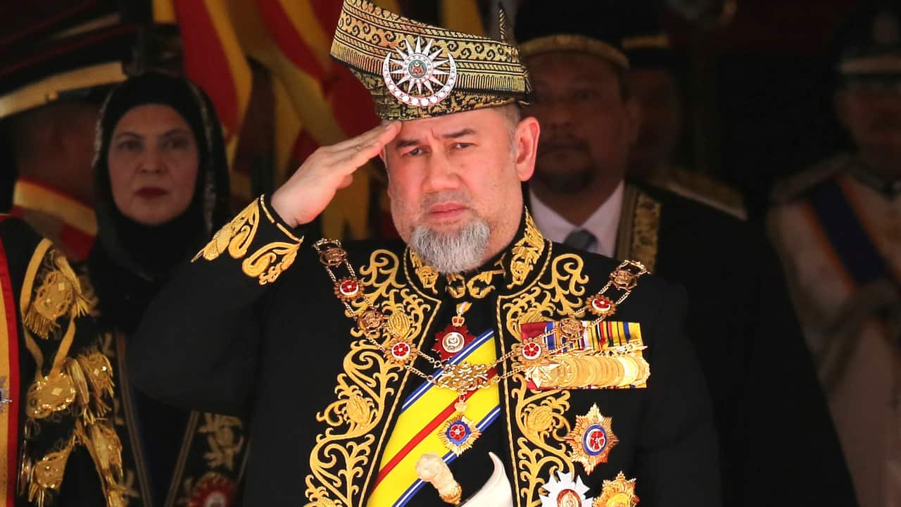 Malaysian King Sultan Muhammad V salutes during the national anthem at the opening of the 14th parliament session at the Parliament house.