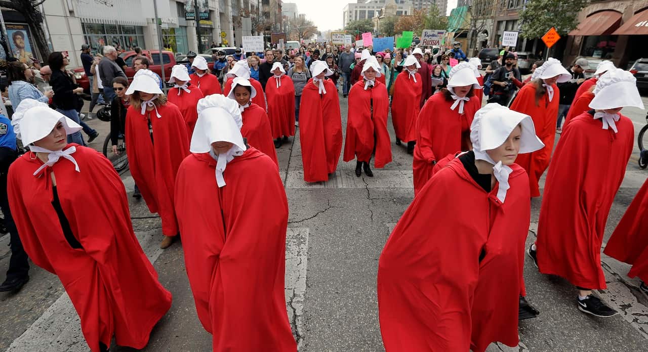 Texas Handmaids lead a women's march to the Texas State Capitol on the one-year anniversary of President Donald Trump's inauguration.