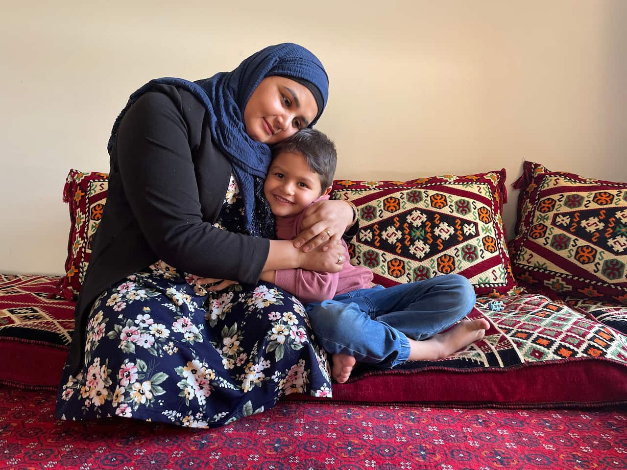 Mariam Aslami is comforted by her son. 