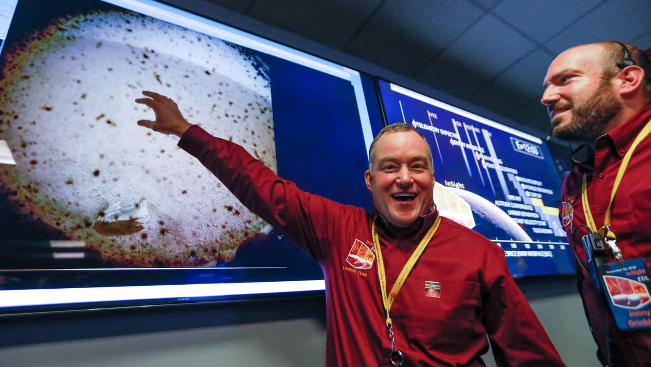 Tom Hoffman (L), InSight Project Manager, NASA JPL points to the first image to be seen from the Mars InSight lander on 26 November 2018.