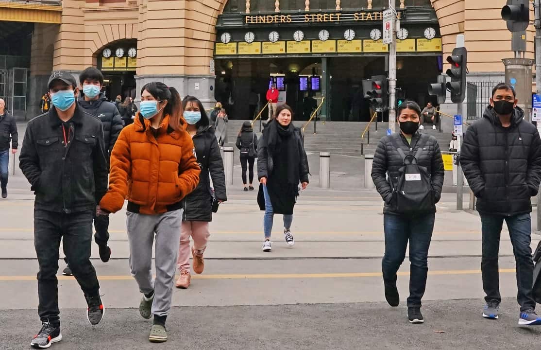 People leave Flinders Street Station while while wearing face masks as a preventive measure against the spread of novel coronavirus.