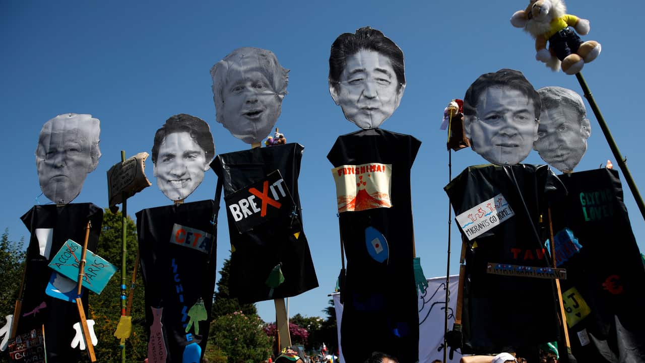 Anti-G7 activists carry pictures of the G-7 leaders during a protest in Hendaye, France.