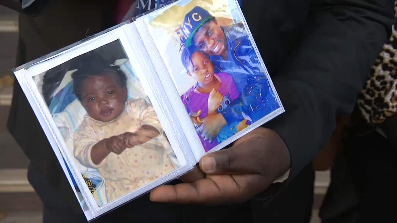 Parents show photos of the late nine-year-old Miata Jibba outside the State Coroner's Court.