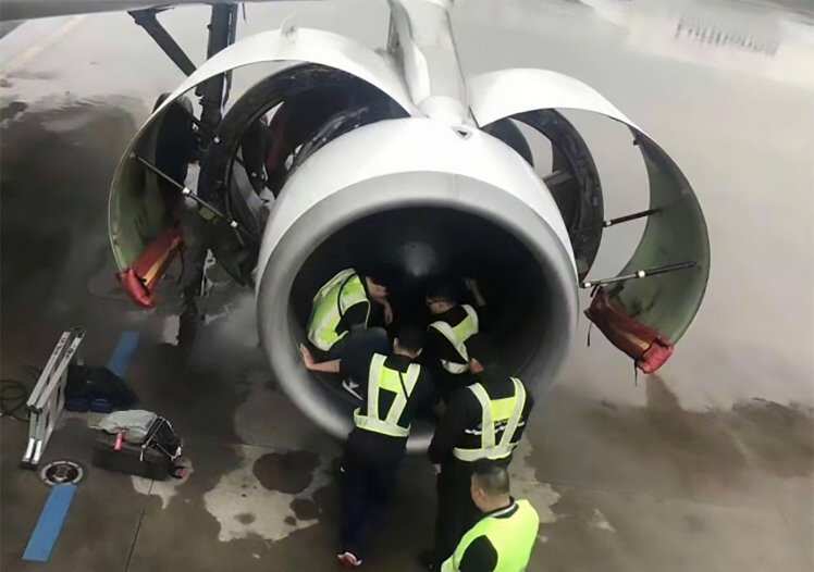 Airport staff checking a plane engine