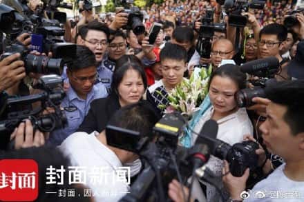 A massive media scrum surround the reunited family. 