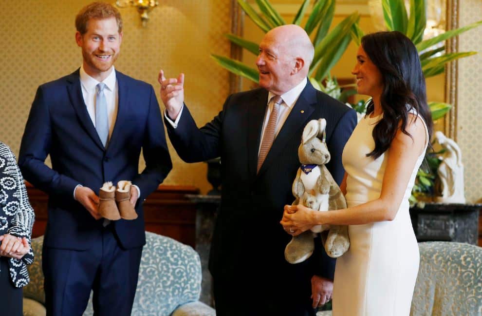 Meghan, right, Duchess of Sussex, reacts as she and Prince Harry, left, receive gifts from Australia's Governor General Sir Peter Cosgrove in Sydney.