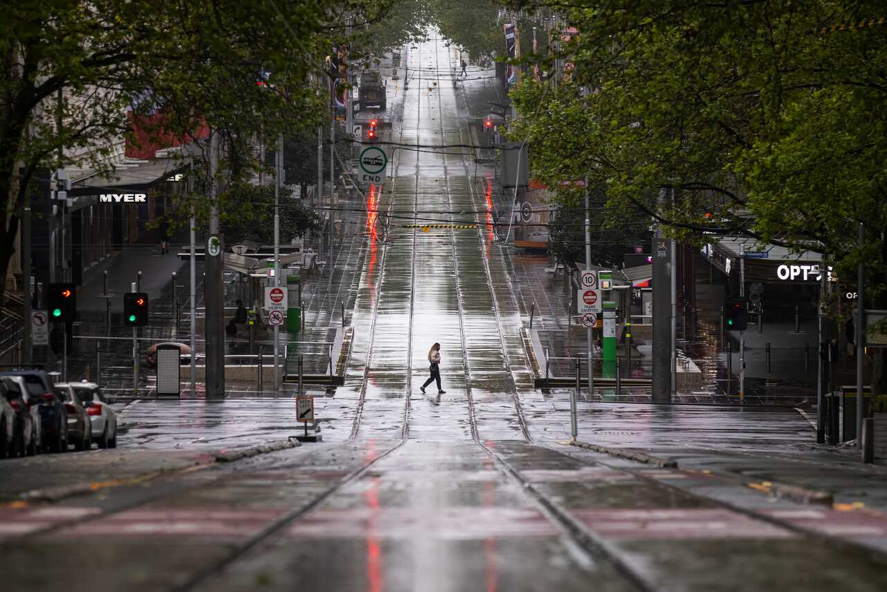 Lone person crosses tram tracks on Bourke Street in Melbourne