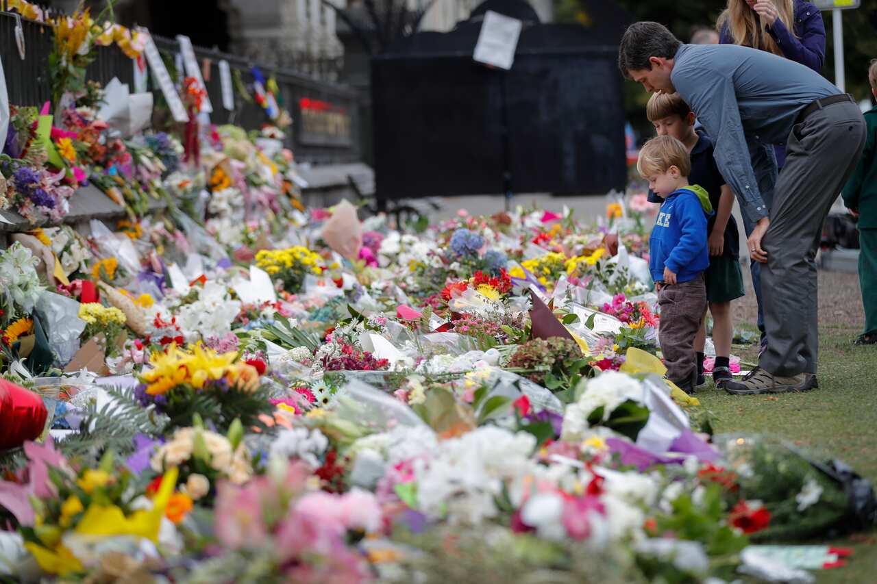 Mourners lay flowers on a wall at the Botanical Gardens in Christchurch.