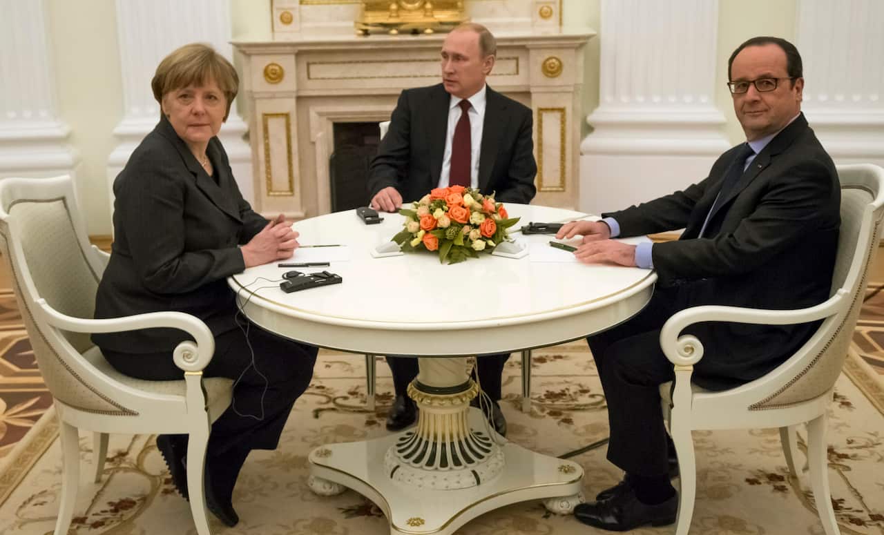 Russian President Vladimir Putin, center, French President Francois Hollande, right, and German Chancellor Angela Merkel pose for a photo during their meeting in the Kremlin in Moscow, Russia, Friday, Feb. 6, 2015
