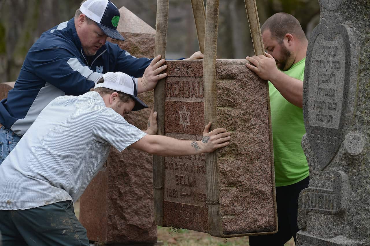 Volunteers from a local monument company helped to reset vandalized headstones in the cemetery in 2017.