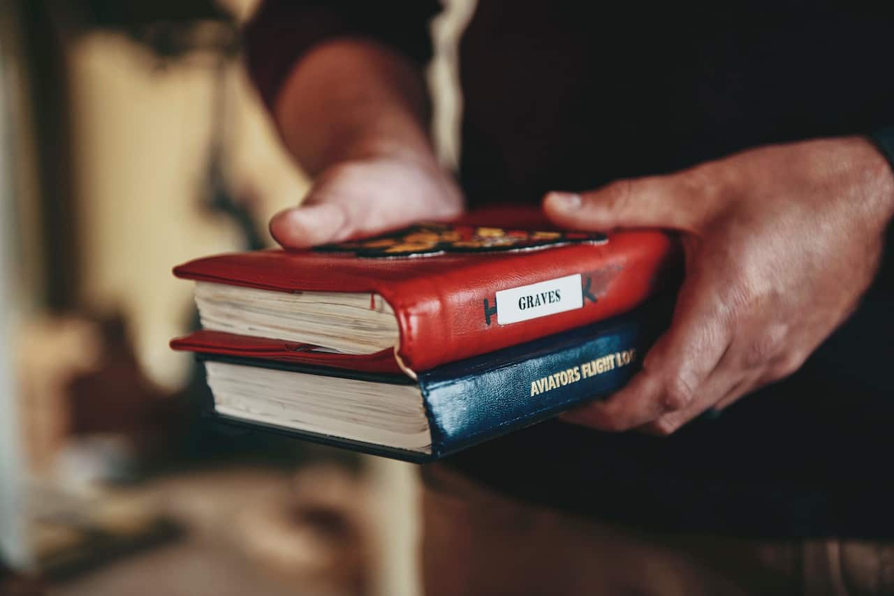 Lieutenant Graves with Navy flight log books.