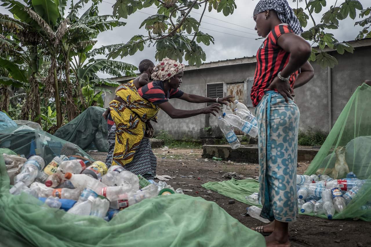 A member of the Abobo women’s association sorts through plastic waste.