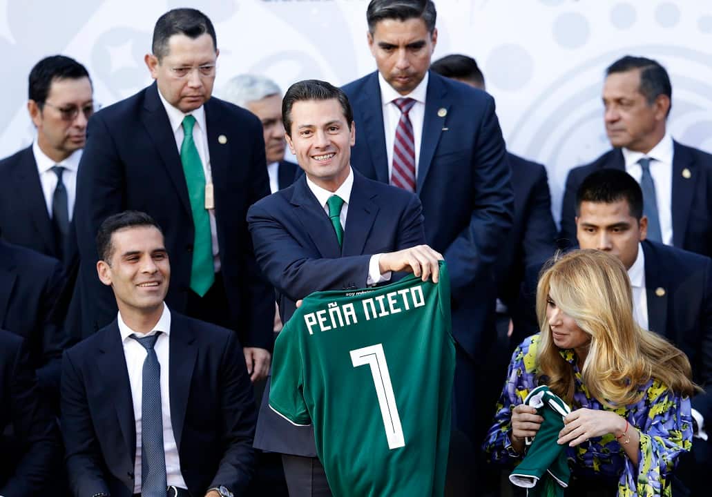 Mexican President Enrique Pena Nieto holds up a Mexican national soccer team jersey given to him by team captain Rafael Marquez, left.